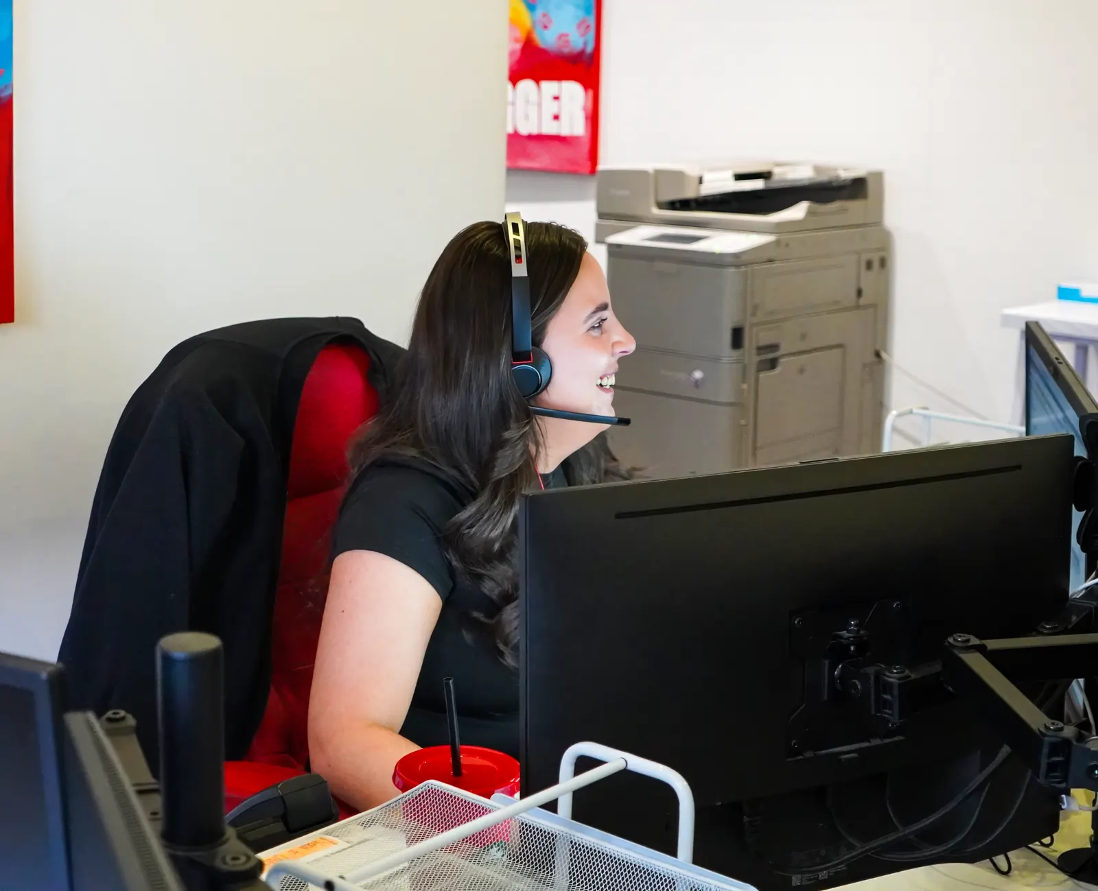 A smiling G4 Claims team member on a call at her desk in our Wishaw office
